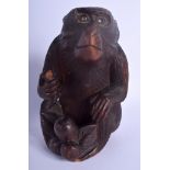 AN EARLY 20TH CENTURY JAPANESE MEIJI PERIOD CARVED WOOD FIGURE OF AN APE modelled holding a fruitin