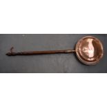 AN EARLY 20TH CENTURY COPPER BED WARMING PAN, formed with a wooden handle. 107 cm long.