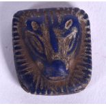 AN EARLY 20TH CENTURY CARVED LAPIS PLAQUE, forming the face of a lion. 2.25 cm x 2.25 cm.