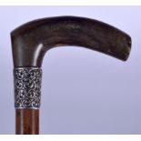 AN EARLY 20TH CENTURY RHINOCEROS HORN HANDLED WALKING STICK, formed with silver repousse collar. 89