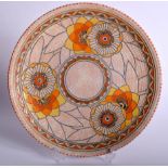 A CHARLOTTE RHEAD POTTERY CHARGER, decorated with bold foliage, signed. 32 cm wide.