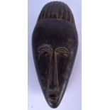 AN IVORY COAST BAOULE / BAULE WOODEN MASK, formed with an elongated face. 37 cm long.