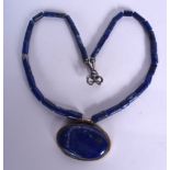 AN EARLY 20TH CENTURY LAPIS LAZULI PENDANT, formed upon a cylindrical bead necklace. 54 cm long.