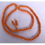AN AMBER TYPE NECKLACE, formed with spherical shaped beads. 88 cm long.