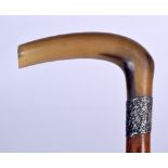 AN EARLY 20TH CENTURY RHINOCEROS HORN HANDLED WALKING STICK, formed with a silver repousse collar a