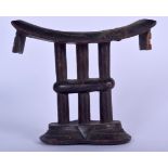 AN AFRICAN CARVED WOODEN TRIBAL NECK REST, formed with triple column support. 15.5 cm x 16.5 cm.