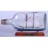 A GERMAN SHIP IN A BOTTLE, together with wooden plinth, “Schoner Hamburg”. 21 cm wide.