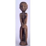 AN EARLY 20TH CENTURY AFRICAN CARVED HARDWOOD TRIBAL FIGURE, in the form of a male with elongated l