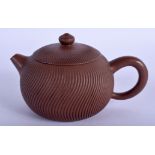 A CHINESE YIXING POTTERY TEAPOT AND COVER 20th Century, of spiralised form. 13.5 cm wide.