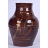 A HUGO GUINNESS STUDIO POTTERY VASE, formed with coloured streaks, signed. 24.5 cm high.