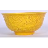 A CHINESE YELLOW GLAZED PORCELAIN BOWL BEARING QIANLONG MARKS, decorated with dragons amongst the c