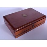 AN ANTIQUE WOODEN WRITING BOX, inset with brass cartouche. 34 cm wide.