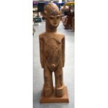 AN AFRICAN CARVED HARDWOOD TRIBAL STATUE, formed standing. 71 cm high.