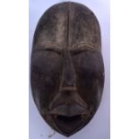 AN IVORY COAST WOODEN DAN MASK, carved with slit eyes and exaggerated features. 38 cm x 20 cm.§