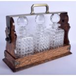 A LARGE EDWARDIAN OAK AND CUT CRYSTAL TRIPLE TANTALUS. 45 cm x 32 cm.