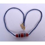 AN EARLY 20TH CENTURY CHINESE ZHU OR DZI BEAD LAPIS LAZULI NECKLACE, formed with a yellow metal cla