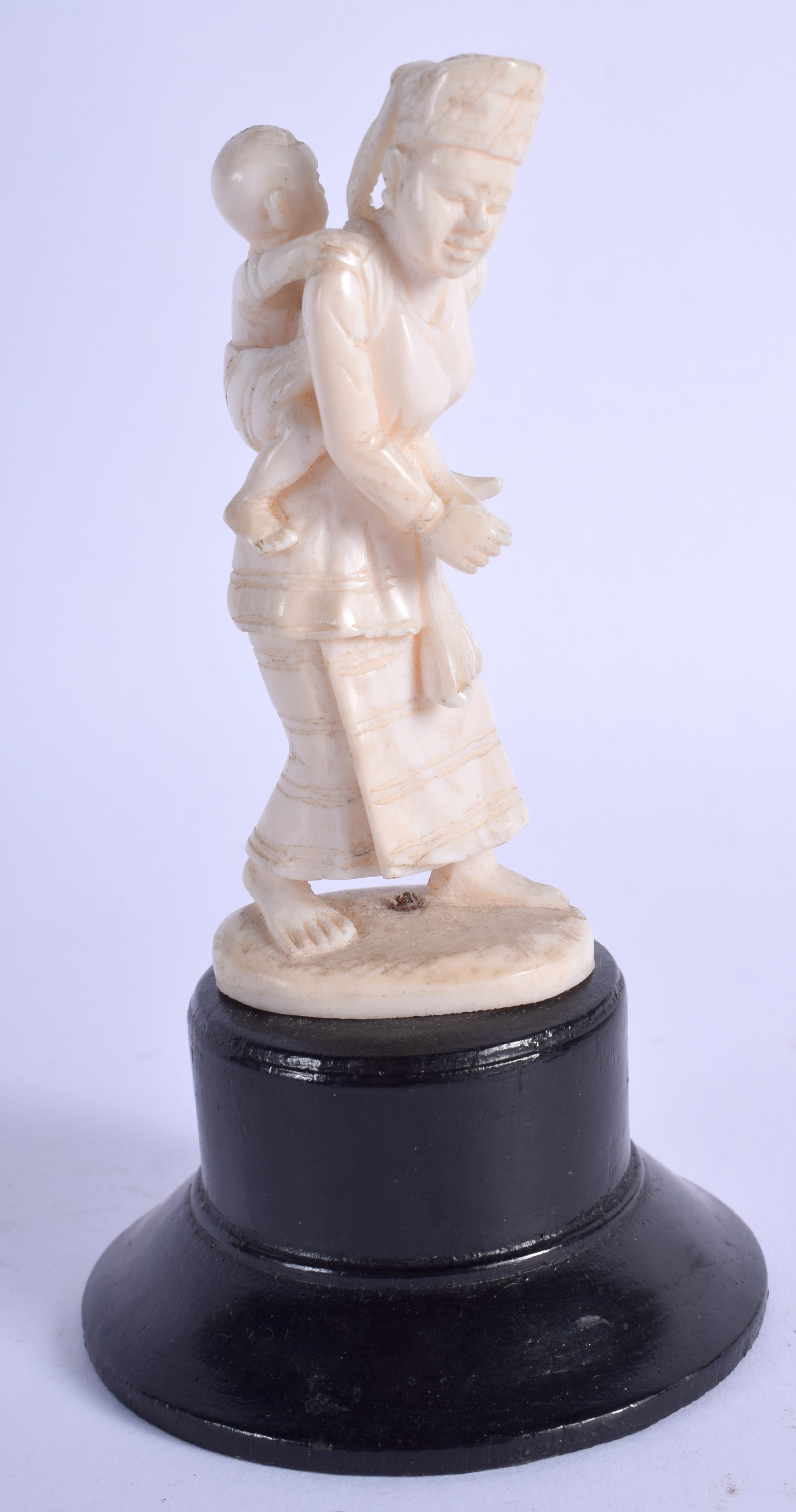 AN EARLY 20TH CENTURY INDIAN CARVED IVORY FIGURE, formed as a mother and child. Total heigh 11.5 cm.