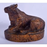 A 17TH CENTURY INDIAN CARVED MARBLISED STONE COW modelled recumbant upon an oval base. 11 cm x 9 cm.