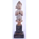 A NIGERIAN YORUBA WOODEN FERTILITY FIGURE, formed as a female squeezing her breasts. 32 cm high.