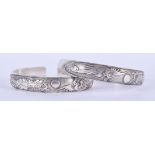 A PAIR OF CHINESE WHITE METAL BANGLES. 7.5 cm wide.