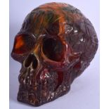 AN AMBER TYPE SCULPTURE OF A SKULL. 15 cm x 11 cm.