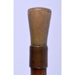 AN EARLY 20TH CENTURY RHINOCEROS HORN HANDLED WALKING CANE, formed with a yellow metal collar. 86 cm