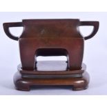 A CHINESE BRONZE CENSER ON STAND, formed with twin handles. 11 cm x 15.5 cm.