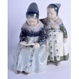 A ROYAL COPENHAGEN PORCELAIN FIGURINE, formed as two girls reading a book. 22 cm x 15 cm.