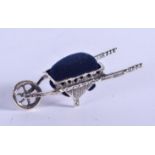 A SILVER WHEELBARROW PIN CUSHION. 3 cm wide.