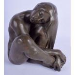 A 1980S CARVED EUROPEAN VOLCANIC LAVA STONE FIGURE OF A NUDE FEMALE modelled resting. 19 cm x 23 cm.