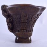 A CHINESE CARVED BUFFALO HORN LIBATION CUP, formed depciting chilong and symbols. 11.5 cm x 13.5 cm.