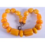 A 1950S CARVED AMBER NECKLACE. 36 cm long.