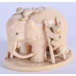A 19TH CENTURY JAPANESE MEIJI PERIOD CARVED IVORY OKIMONO modelled as figures upon an elephant. 7 cm