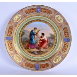A FINE LARGE 19TH CENTURY VIENNA PORCELAIN CHARGER painted with two figures within a landscape. 35 c