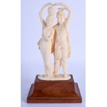 AN EARLY 20TH CENTURY ANGLO INDIAN CARVED IVORY FIGURE OF A DANCING COUPLE modelled upon a wood base
