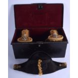 A FRAMED 19TH CENTURY NAVAL HAT with matching epaulettes, within a tin case. (4)