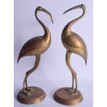 A PAIR OF 19TH CENTURY MIDDLE EASTERN BRASS BIRDS upon circular bases. 33 cm high.