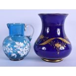 A VENETIAN BLUE GLASS VASE together with a similar white enamelled jug. 19 cm & 15 cm high. (2)