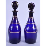 A PAIR OF ANTIQUE BRISTOL BLUE BOTTLES. 25 cm high.