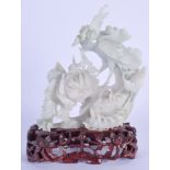 A 1930S CHINESE CARVED JADEITE FIGURE OF A BIRD modelled perched amongst foliage. Jadeite 11 cm x 13