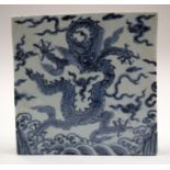 A CHINESE BLUE AND WHITE MING STYLE DRAGON TILE. 18 cm square.
