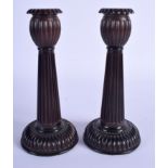 A PAIR OF ART DECO CARVED BLACKWOOD CANDLESTICKS of chrysanthemum moulded form. 19 cm high.