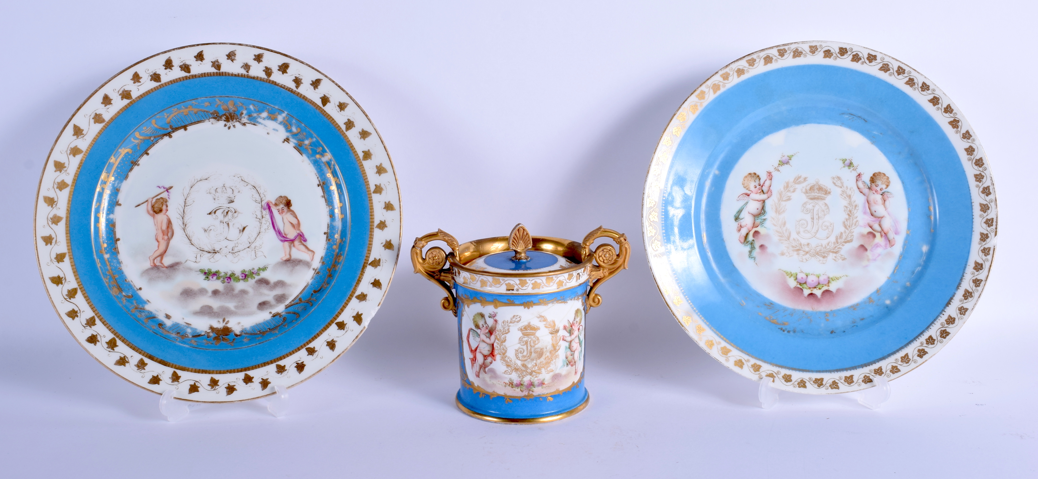 A PAIR OF LATE 19TH CENTURY FRENCH POWDER BLUE PLATES painted with putti, together with a sugar bowl