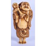 A 19TH CENTURY JAPANESE MEIJI PERIOD CARVED IVORY NETSUKE modelled as Hotei holding a boy blowing a