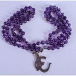 A 1950S CHINESE CARVED BUDDHISTIC AMETHYST NECKLACE with white metal clasp. 68 cm long.