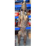 A LARGE AFRICAN CARVED FERTILITY FIGURE, in the form of a seated female holding an infant. 143 cm x