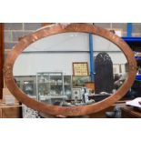 AN ARTS AND CRAFTS COPPER MIRROR by Archibald Knox, decorated with strap banding. 112 cm x 75 cm.