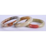 THREE 19TH CENTURY CHINESE CARVED JADE HARDSTONE BANGLES. 8.5 cm wide. (3)