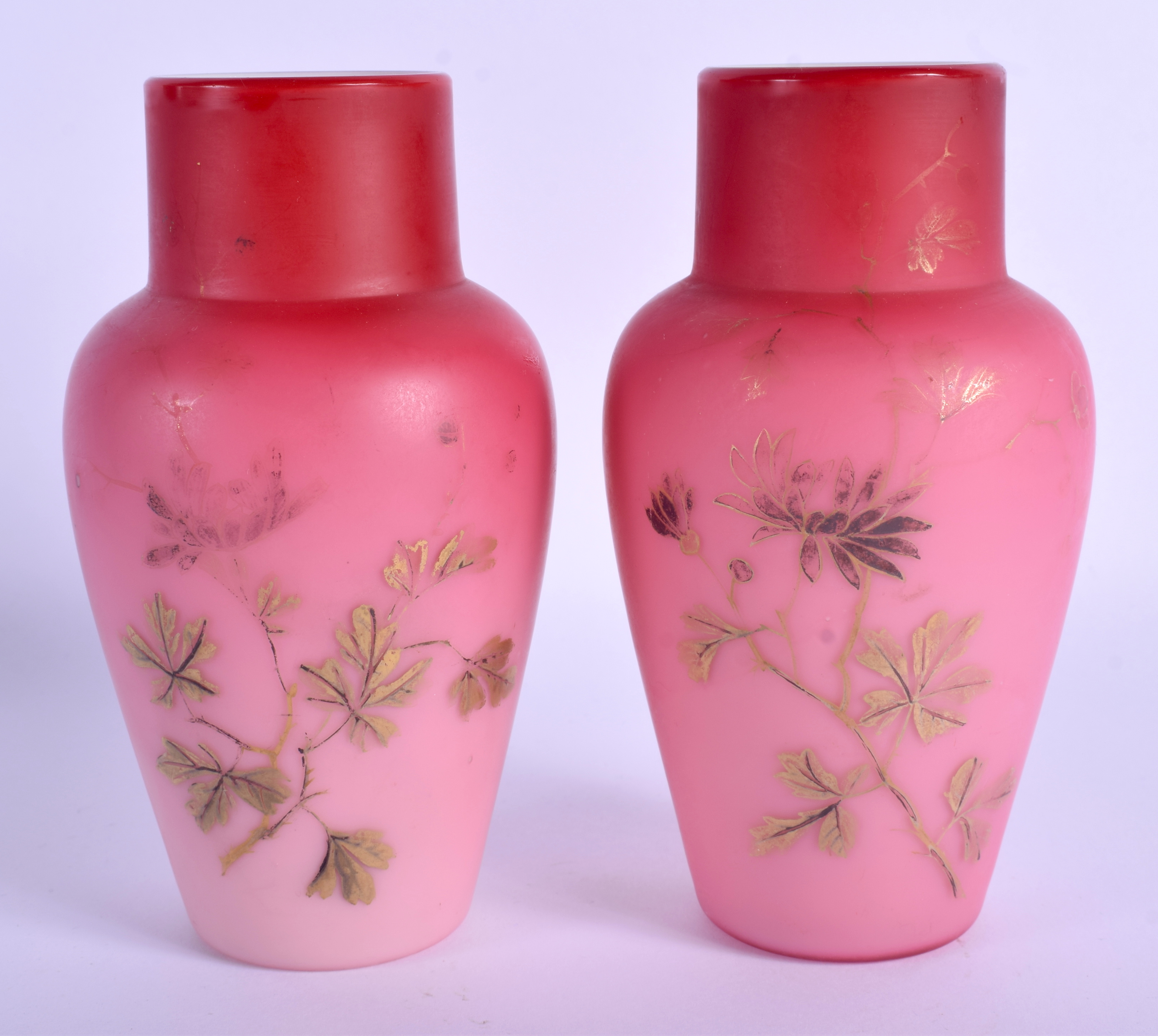 A PAIR OF EDWARDIAN PINK AND WHITE OPALINE GLASS VASES decorated with gilt foliage. 15.5 cm high.