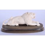 A 19TH CENTURY INDIAN CARVED IVORY AND RHINOCEROS HORN FIGURE OF A LION modelled recumbent 14.25 cm